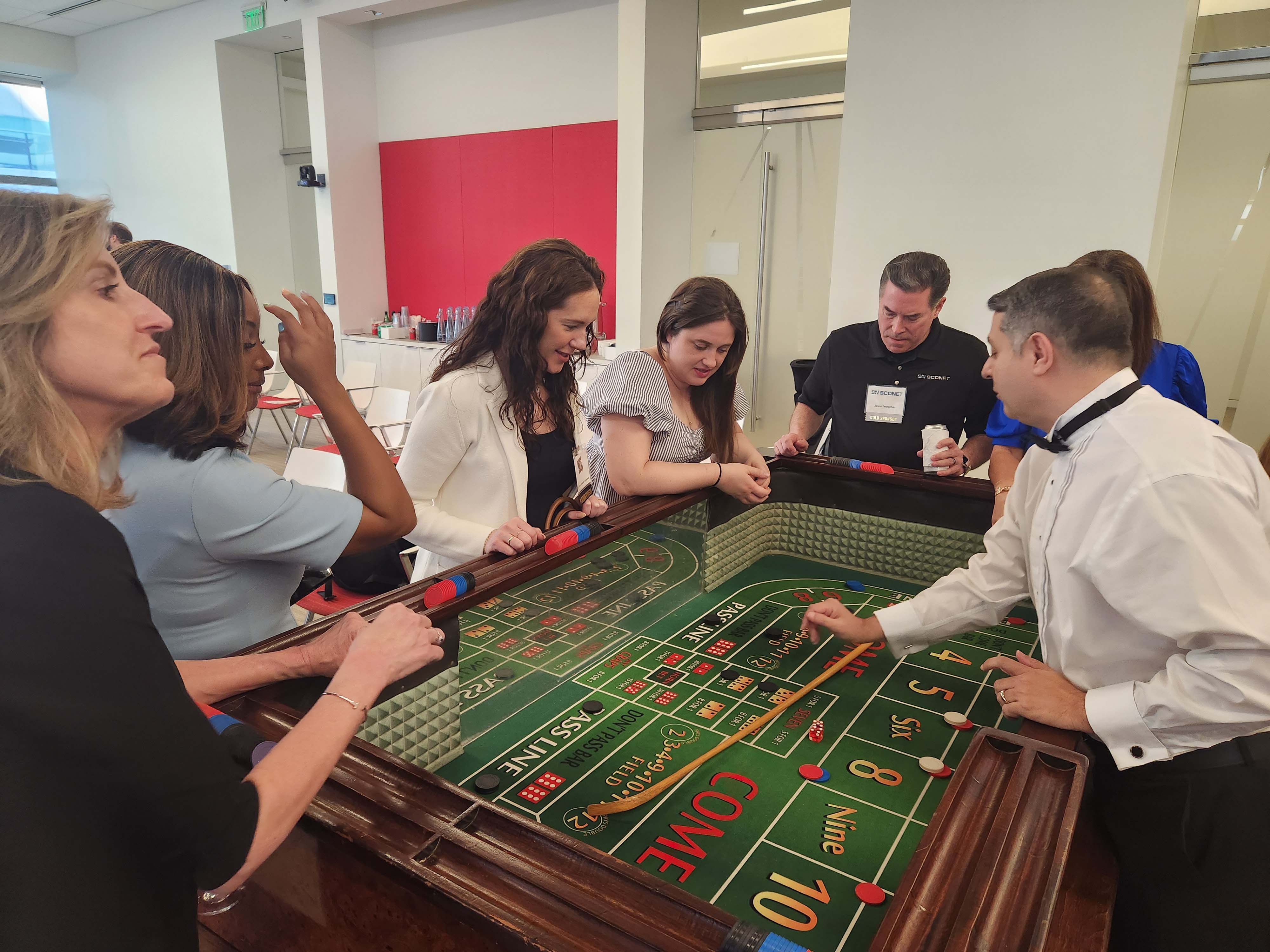 People surrounding the Club Craps table at an employee appreciation casino night party in Houston.