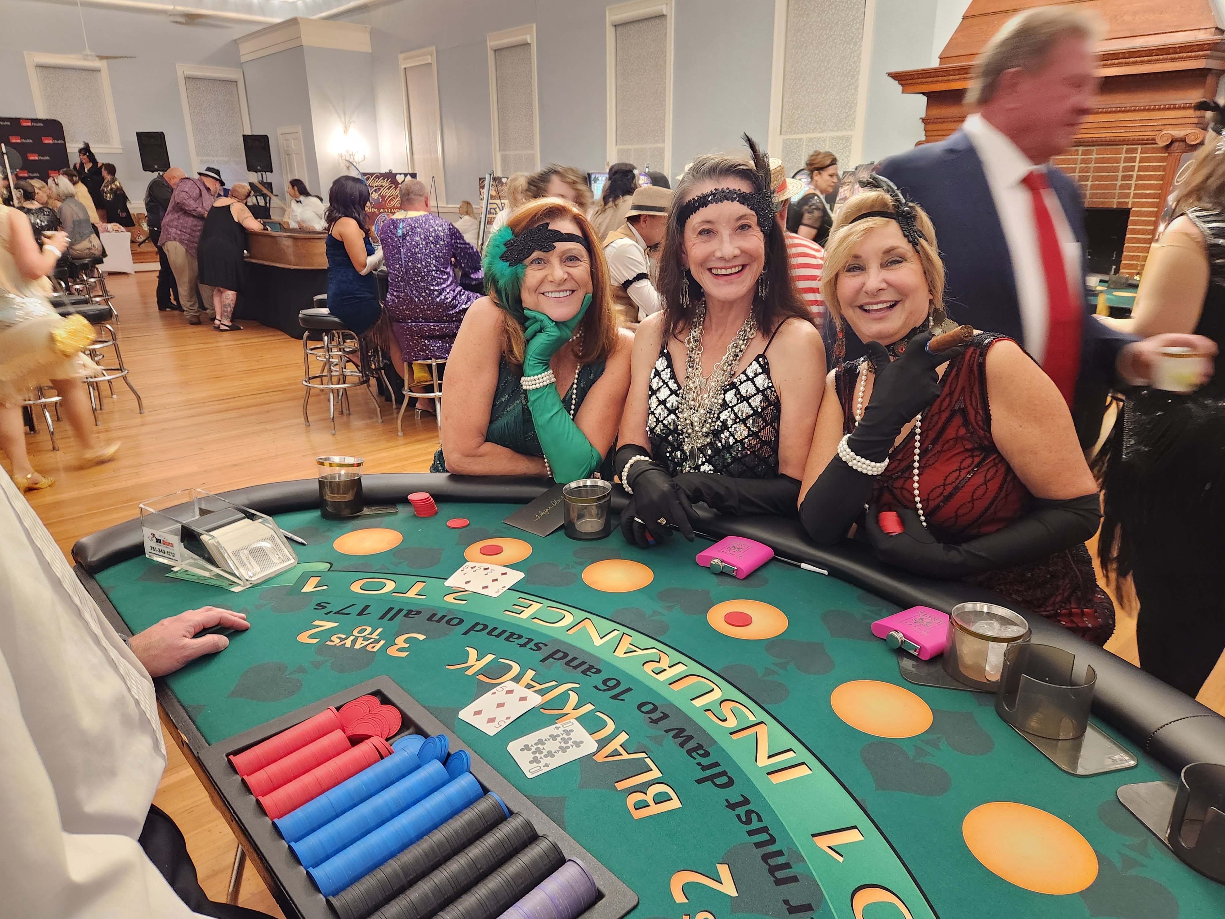 People playing blackjack at a roaring 20s casino night party in Houston.